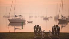Two chairs at sunset in front of the marina at Inn at Perry Cabin St Michaels Harbor in Maryland, USA