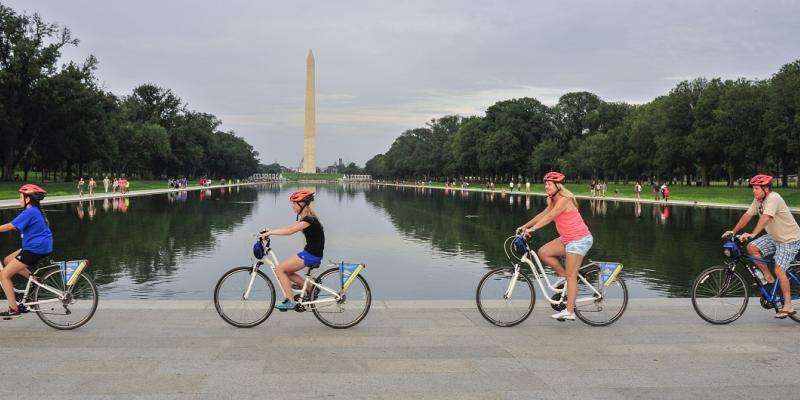 People biking past the Washington Monument on a tour with Bike & Roll in Washington, DC, USA